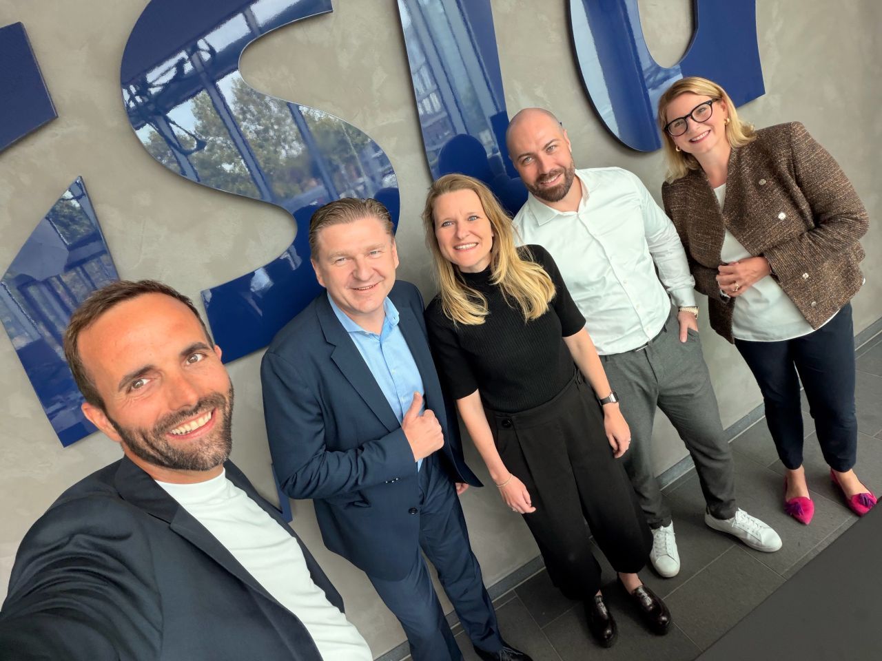 The ista and Homenergy teams in front of the ista logo
